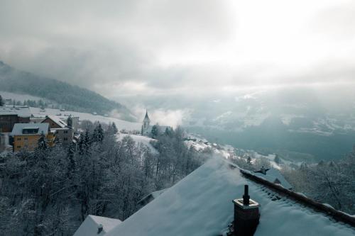a snow covered town with a church on a mountain at Apartment Raingüetli in Amden