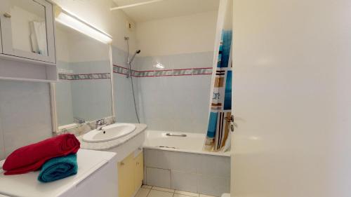 une salle de bain avec un lavabo et une baignoire dans l'établissement Le Corsaire Face Mer, à Saint-Gilles-Croix-de-Vie