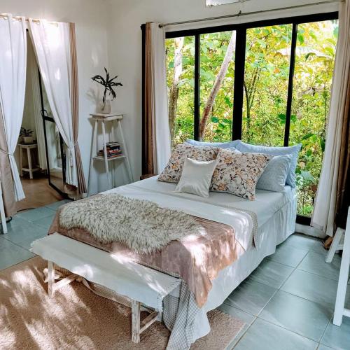 a bedroom with a bed and a large window at RP Botanical Park, Hotel & Resort in Tagbina