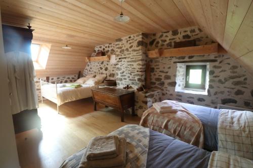 a room with two beds in a log cabin at La Fermette de Loucheyre in Saint-Amandin