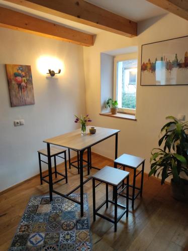 a dining room with a table and two stools at Ferienwohnungen in kleiner historischer Altstadt in Sulzbach-Rosenberg