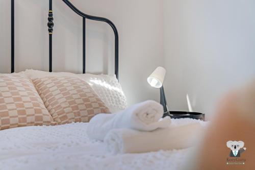 a stuffed animal sitting on a bed with a lamp at KozyGuru | Cobbitty | Brand New Stylish 4BR House in Cobbitty