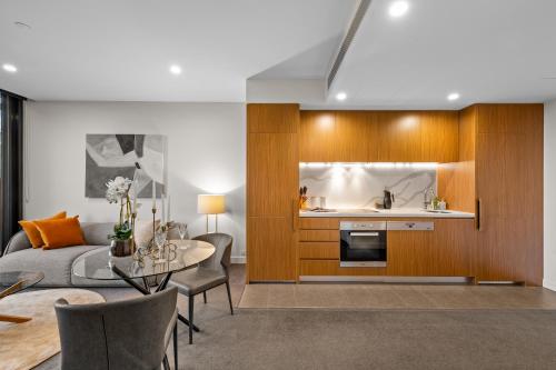 a living room with a table and a kitchen at Parkside Perfection Near The CBD in Melbourne