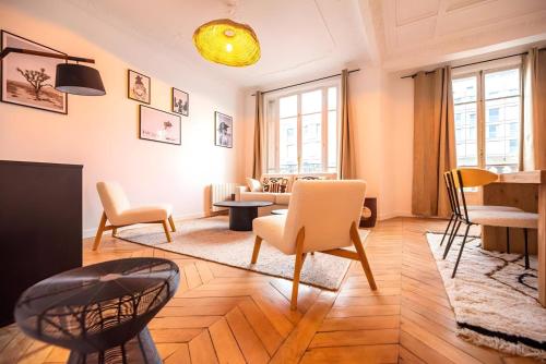 un salon avec des chaises et une table dans l'établissement TBS 326 - Superb apartment with Eiffel Tower view, à Paris