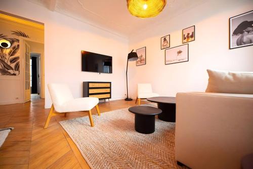 un salon avec un canapé et une table dans l'établissement TBS 326 - Superb apartment with Eiffel Tower view, à Paris