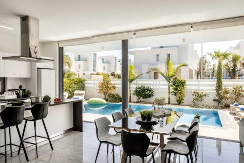 an open kitchen and dining room with a view of a pool at Diamond villas in Protaras