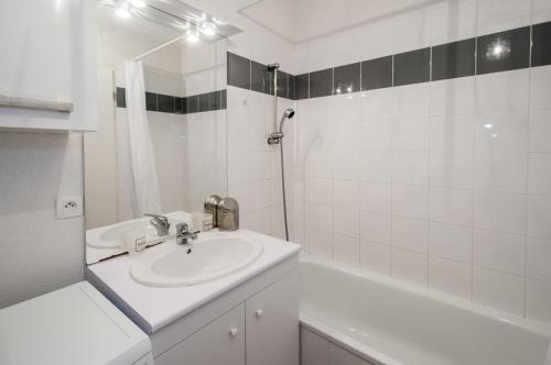 スラック・シュル・メールにあるappartement dans une residence en front de mer - 4910の洗面台とバスタブのある白いバスルーム