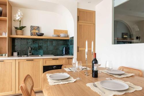 - une cuisine avec une table en bois, des assiettes et des verres à vin dans l'établissement Montparnasse - Élégance & Confort au Cœur de Paris - Haystia, à Paris