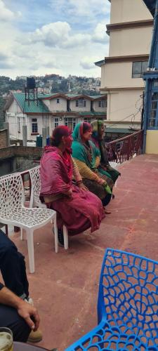 a group of people sitting on a bench at The Heritage jasmine lodge B&B in Shimla