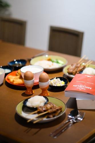 a wooden table with plates of food on it at Blu Dock Restel Bangkok in Bangkok