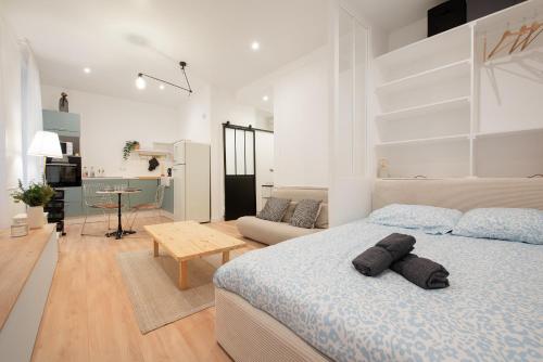 une chambre avec un lit et un salon dans l'établissement Le Nuage - Appartement Moderne à 2 pas de la Gare, à Toulouse