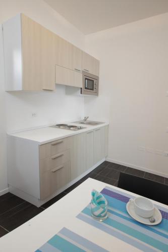 a kitchen with white cabinets and a plate on a table at Residence Città Ideale in Urbino