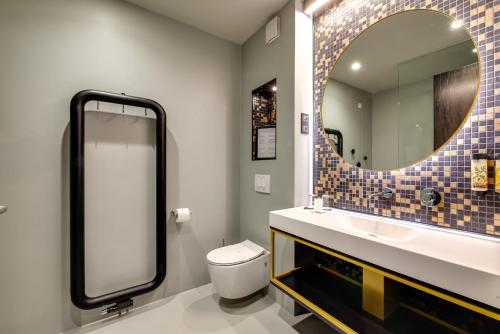 a bathroom with a toilet and a mirror at Lyra Hotel Plitvice in Ličko Petrovo Selo