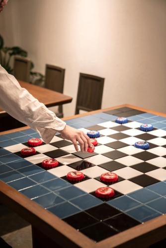 a person playing a game on a chessboard at Blu Dock Restel Bangkok in Bangkok
