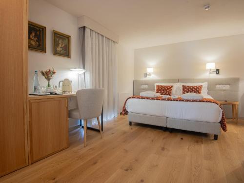 a bedroom with a bed and a desk and a table at Casa da Fonte de Cima in Celorico de Basto