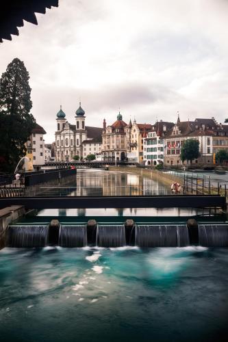 a river in a city with buildings in the background at KB CityRooms Self-Check-In in Luzern