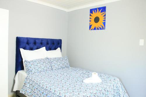 a bedroom with a bed with a blue head board at Gift Guest house 2 in Cravenby