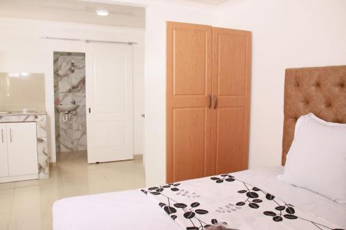 a bedroom with a bed and a wooden door at Gift Guest house 2 in Cravenby