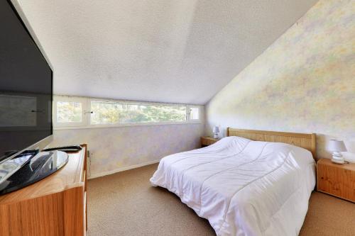 une chambre avec un lit blanc et une fenêtre dans l'établissement Appartement avec terrasse vue mer pour 6 - Arzon, à Arzon