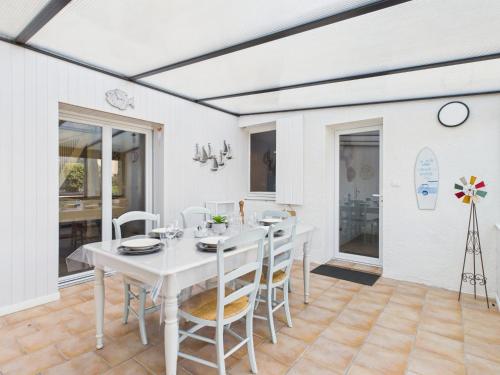 une salle à manger blanche avec une table et des chaises blanches dans l'établissement Jolie maison avec jardin à 450m de la plage pour 8, à Batz-sur-Mer