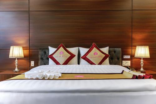 a bedroom with a large bed with two lamps at KHÁCH SẠN SAO MAI in Cao Lãnh