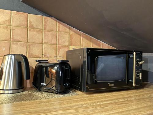a microwave sitting next to a television and a toaster at Historic Residence Apartments at Old Town in Tallinn