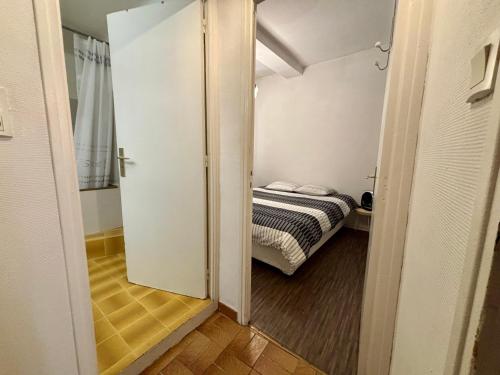 une petite chambre avec un lit dans une pièce dans l'établissement Bel Appartement Centre ville de Perpignan, à Perpignan