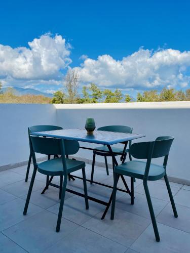 une table et des chaises assises sur une terrasse dans l'établissement Appt Lumineux pieds dans l'eau N181, à Linguizzetta