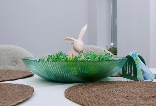 a green bowl on a table with a bunny in it at Apartament Ratuszowy in Cieszyn