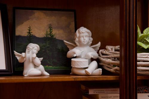 two white angel statues sitting on a shelf at Apartament Ratuszowy in Cieszyn