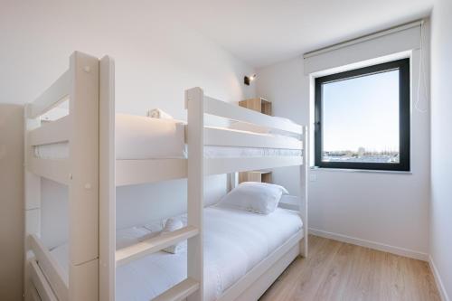a white bunk bed in a white room with a window at Maison Atlantis in Nieuwpoort