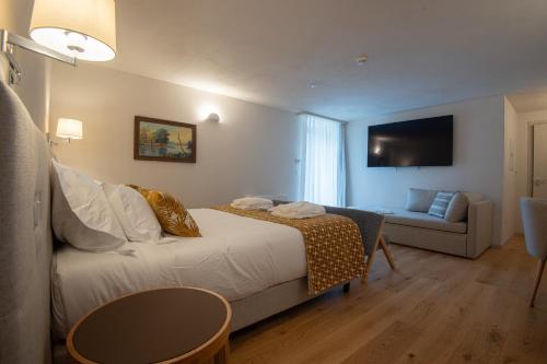 a hotel room with a bed and a couch at Casa da Fonte de Cima in Celorico de Basto