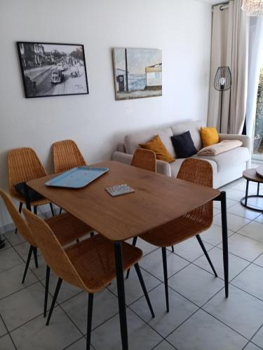 - un salon avec une table et des chaises dans l'établissement T3 rez-de-chaussée lumineux avec terrasse proche plage, à Cucq