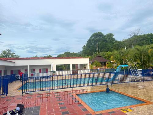 a large swimming pool with a slide in it at Hotel Centro vacacional El Cielo in Rivera
