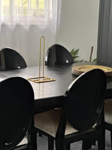 a dining room table with four chairs and a table with plates at Heart of Numbi Villa in The Sands