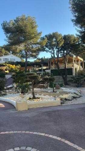 a garden with trees and rocks and a building at Bentley studio in Sanary-sur-Mer