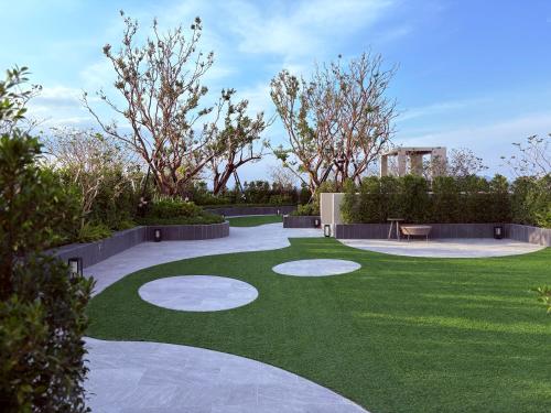 a backyard with a green yard with a patio at Monthly Stay at Escent Trang near Robinson mall in Ban Khuan Khan