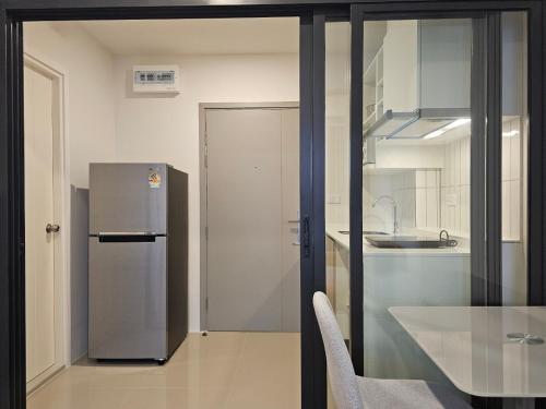 a kitchen with a stainless steel refrigerator and a table at Monthly Stay at Escent Trang near Robinson mall in Ban Khuan Khan