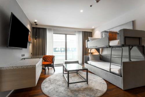 a bedroom with a bunk bed and a living room at Radisson RED Phuket Patong Beach in Patong Beach