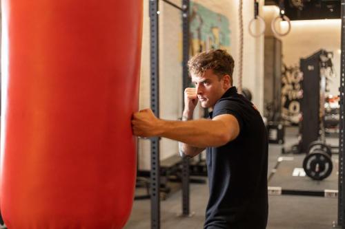 a man standing next to a punching bag in a gym at Radisson RED Phuket Patong Beach in Patong Beach