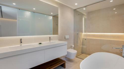 a bathroom with a sink and a toilet and a shower at Pine Cliffs Village in Albufeira