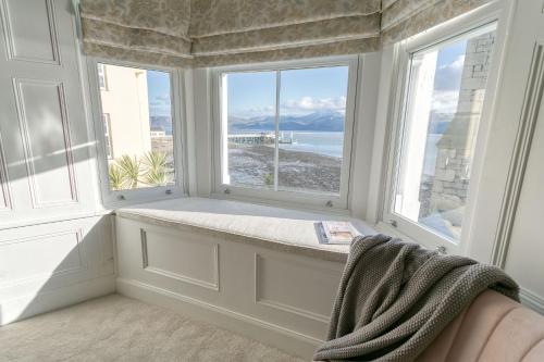 a window seat in a room with two large windows at Craig Hyfryd in Beaumaris