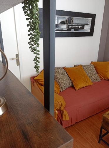 a living room with a couch and a plant at Château, poteries, vins et randonnées in Saint-Amand-en-Puisaye