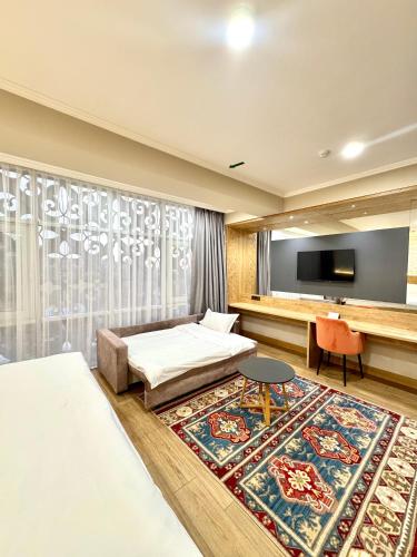 a bedroom with a bed and a flat screen tv at Dami Almaty Hotel in Almaty