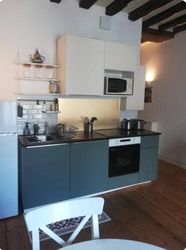 une cuisine avec une cuisinière et un micro-ondes dans l'établissement Cocon dans quartier historique proche gare, à Nantes