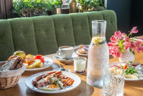 a table with plates of food and a bottle of water at Hotel Královka in Bedřichov