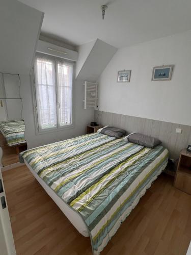 - une chambre avec un grand lit et une couette à rayures dans l'établissement la maison de Luna, cayeux sur mer, baie de somme, à Cayeux-sur-Mer