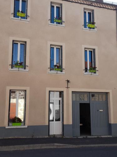 a building with windows and doors with flowers in the window boxes at Ils en ont rêvé in Chambon-le-Château