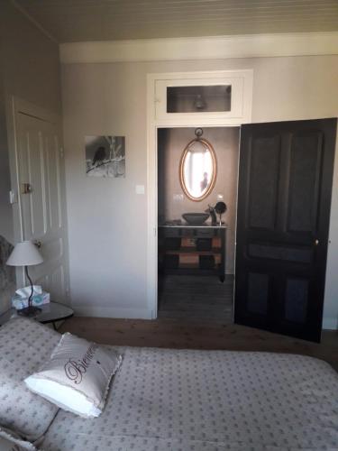 une chambre avec un lit, un miroir et une table dans l'établissement Ils en ont rêvé, à Chambon-le-Château