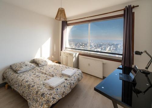 a bedroom with a bed and a large window at Vue imprenable - Garage privé in Rennes
